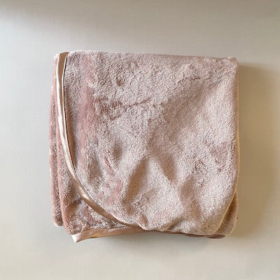 Pink fleece cuddle blanket with satin trim.