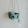 Duck egg blue velvet baby swing with grey ropes and wooden dowels.