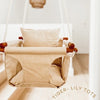 Basketweave cotton texture baby swing with white ropes, and wooden dowels.