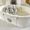 White carry cot with grey monstera leaf