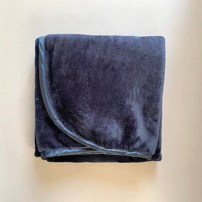 Navy fleece cuddle blanket with satin trim.